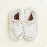 Pair of white fuzzy slippers on a light beige background