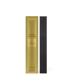 Gold packaging of 'Kyoto in Bloom' with black sticks on a white background