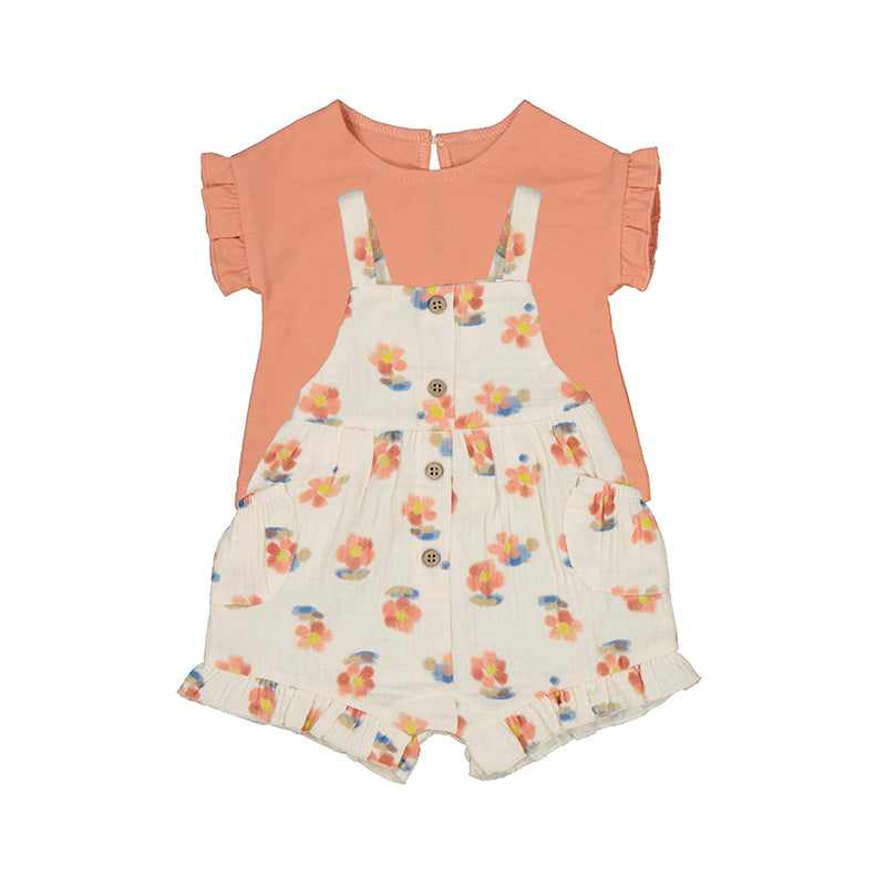 A baby overall set with floral patterns on the shorts and a solid peach color top.