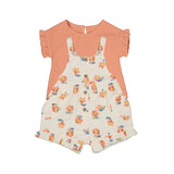 A baby overall set with floral patterns on the shorts and a solid peach color top.