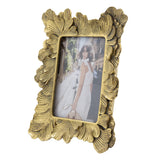 Decorative gold photo frame with a floral design on a white background