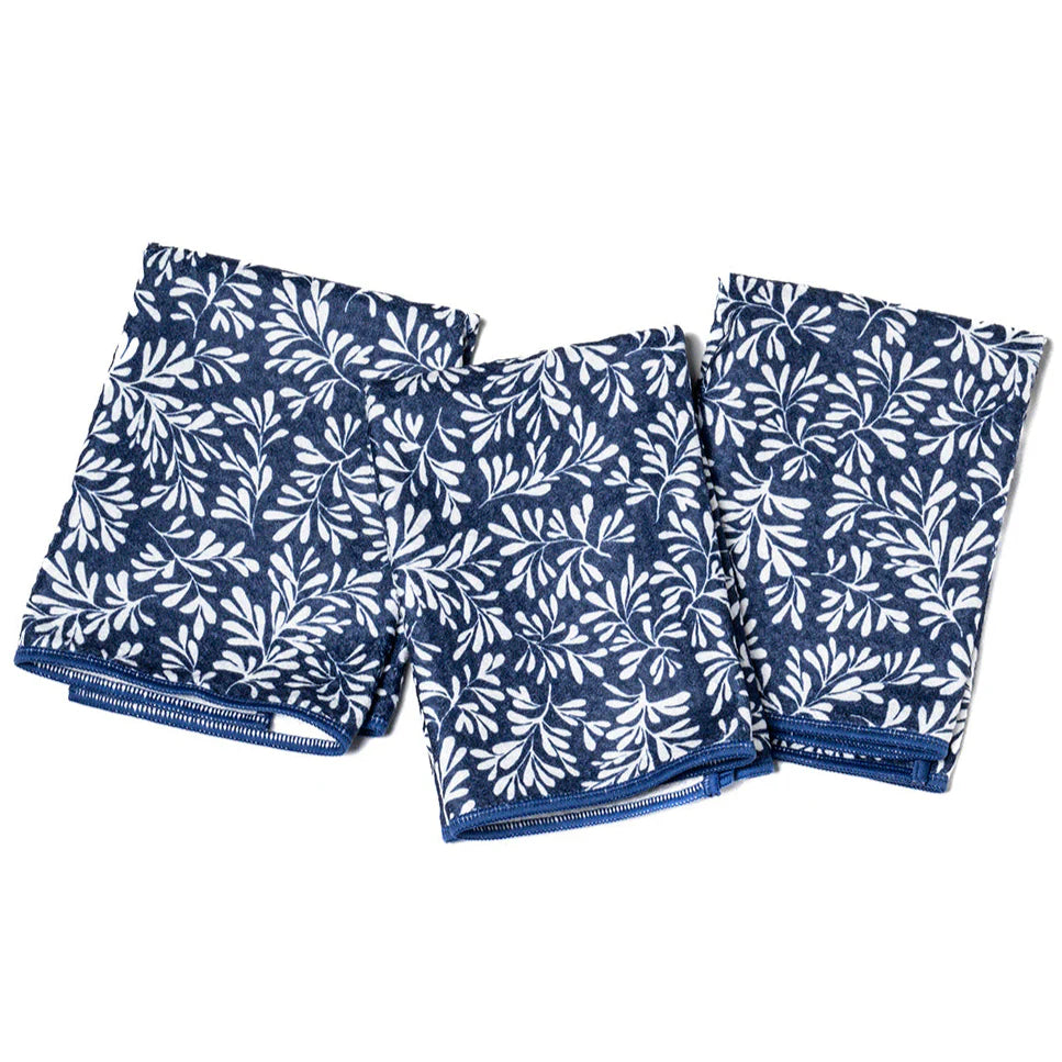 Set of three blue and white patterned napkins on a white background