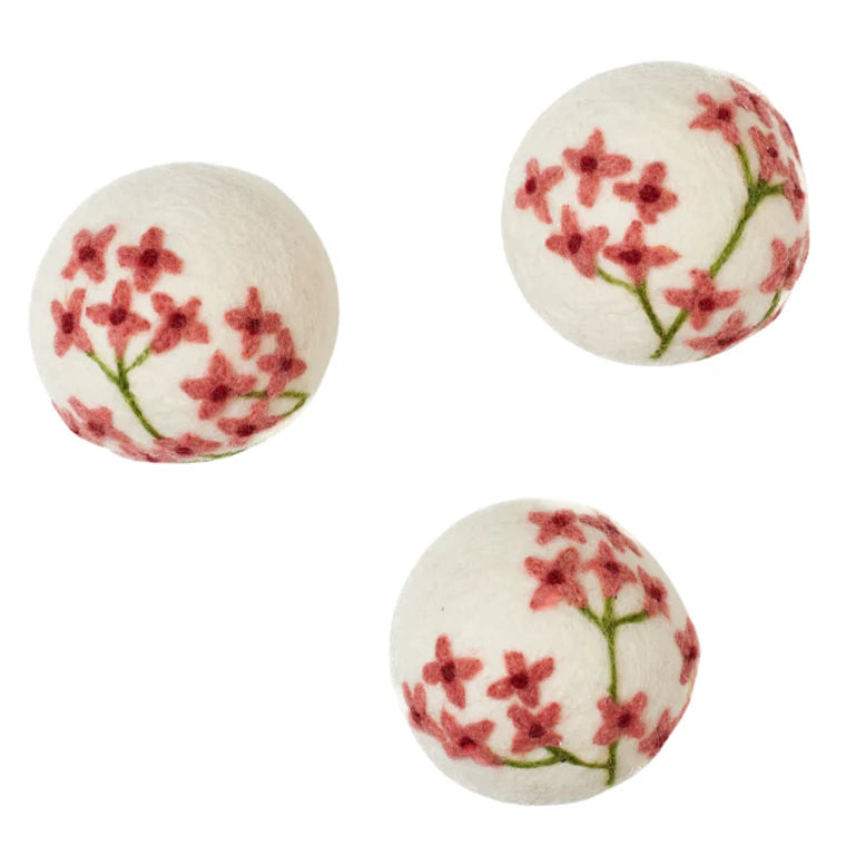 Three spherical bath bombs with floral design on a white background