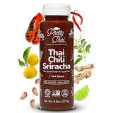 Phetty Thai Thai Chili Sriracha hot sauce bottle with chili peppers, lemon, lime, and ginger on a white background