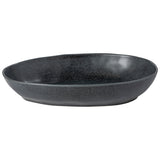 An oval-shaped, matte black ceramic baking dish with a textured surface.
