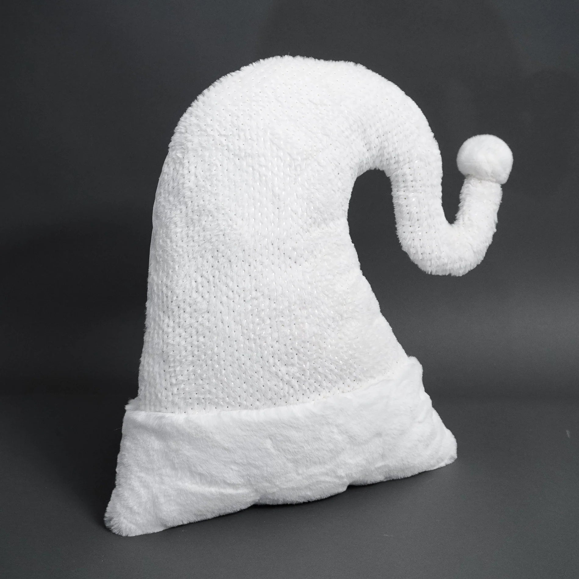 White ghost-shaped pillow on a dark background