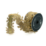 Decorative gold ribbon on a spool with visible brand name on a white background