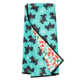 Folded towel with black dog pattern on a turquoise background