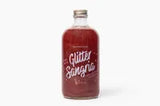 A clear glass bottle filled with dark red liquid, featuring a white label with the text 'Glitter Sugarfina' in stylized lettering, set against a plain white background.