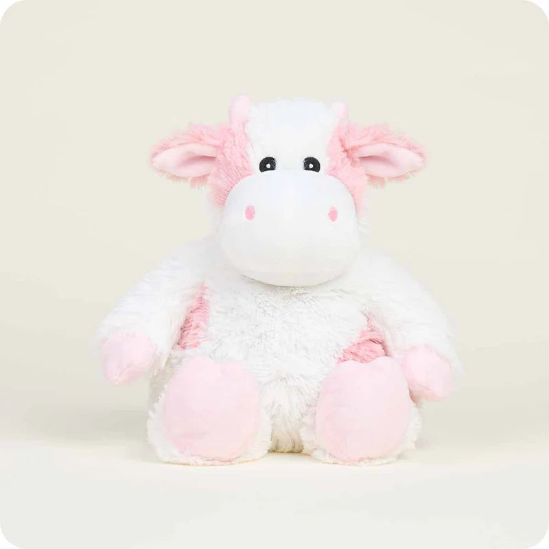 Plush cow toy with pink and white colors on a light background