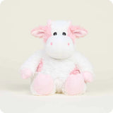 Plush cow toy with pink and white colors on a light background