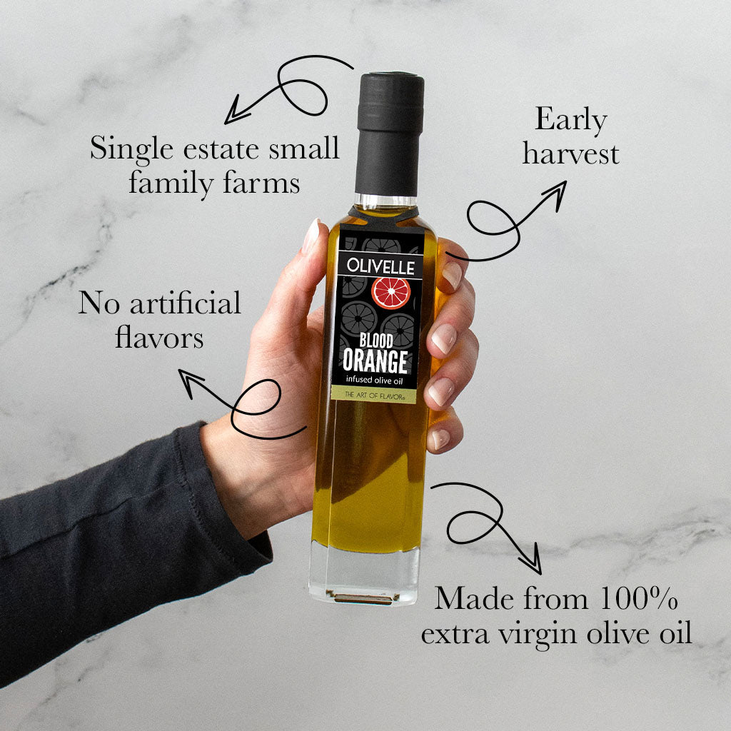 Bottle of Olivelle Blood Orange olive oil held by a hand on a marble background with text about the product.