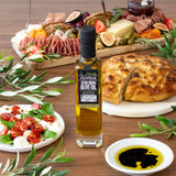 Olivelle olive oil bottle with a charcuterie board and bread on a wooden table.