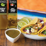 Olivelle jalapeno lime and fiesta spice olive oils with tacos and salsa on a wooden table.