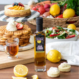 Olivelle Sicilian Lemon infused olive oil bottle on a table with waffles, salad, and lemons.