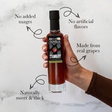 Hand holding a bottle of Olivelle strawberry syrup with text highlighting its features on a marble background.