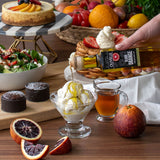 Table with various desserts, fruits, and a bottle of olive oil.