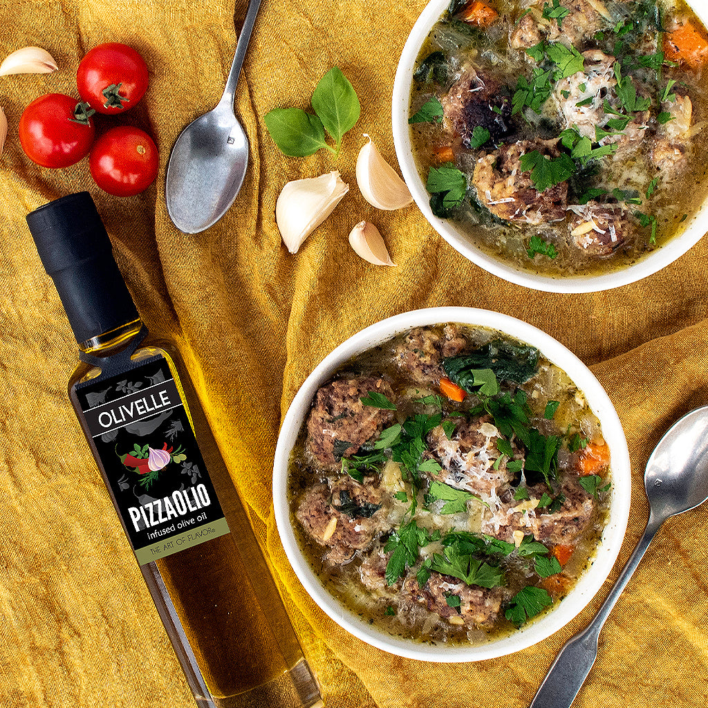 Two bowls of soup with a bottle of Olivelle Pizzaiolo olive oil on a yellow cloth.