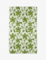 A green and white floral patterned tea towel displayed flat.