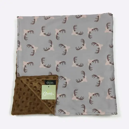 Blanket with deer antler pattern on gray side and brown polka dot pattern on reverse side, on a white background.