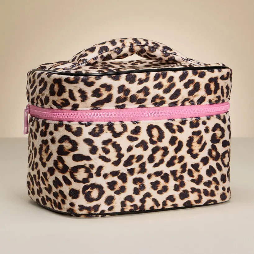 Leopard print cosmetic bag with a pink zipper on a beige background