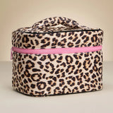 Leopard print cosmetic bag with a pink zipper on a beige background