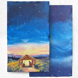 Two rectangular kitchen towels or cloth napkins with a printed night sky and small stable scene, shown overlapping on a white background.