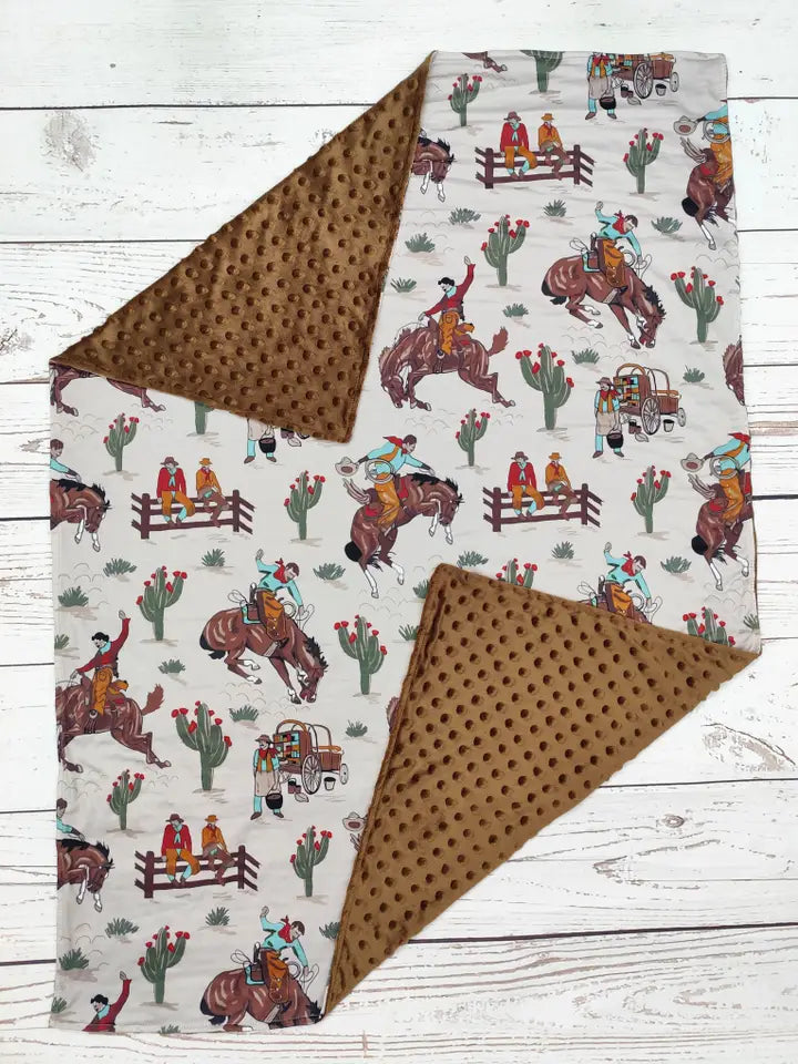 Blanket with cowboy and horse pattern on a wooden surface