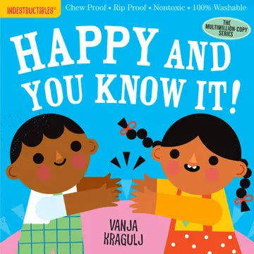Children's book cover titled 'Happy and You Know It!' by Vanja Kragulj, featuring two illustrated children clapping on a bright blue background. The top banner reads 'Indestructibles' and includes product claims like chew proof, rip proof, nontoxic, and 100% washable.