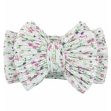 Floral print headband with a large bow on a white background