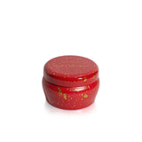 Red candle tin with gold text and decorative elements on a white background