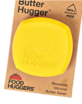 A yellow butter hugger packaged on a cardboard backing with the brand name 'Food Huggers' printed on it. The butter hugger is designed to keep butter fresh and spreadable.