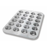 Metal muffin tin with 24 cups on a white background