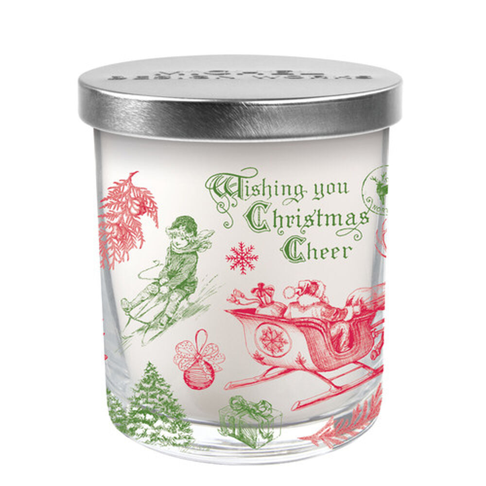 A Christmas-themed candle jar with a white background and red and green holiday motifs, including a reindeer and snowflakes. The lid is silver with a Christmas tree design.