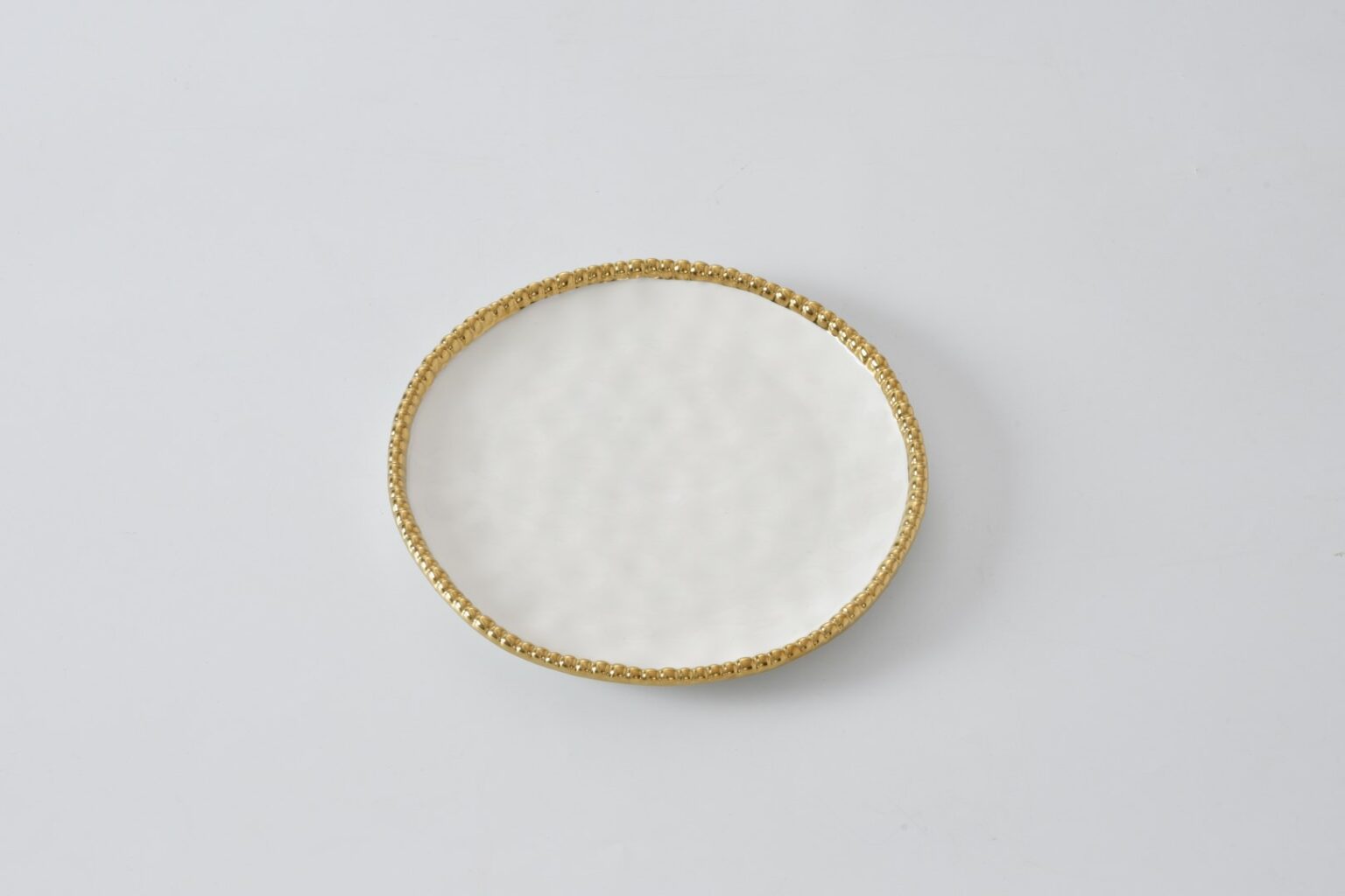A round salad plate with a gold finish on the edge, displayed against a white background.