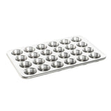 A 24-cup petite muffin pan made of metal, with a smooth surface and no visible handles.