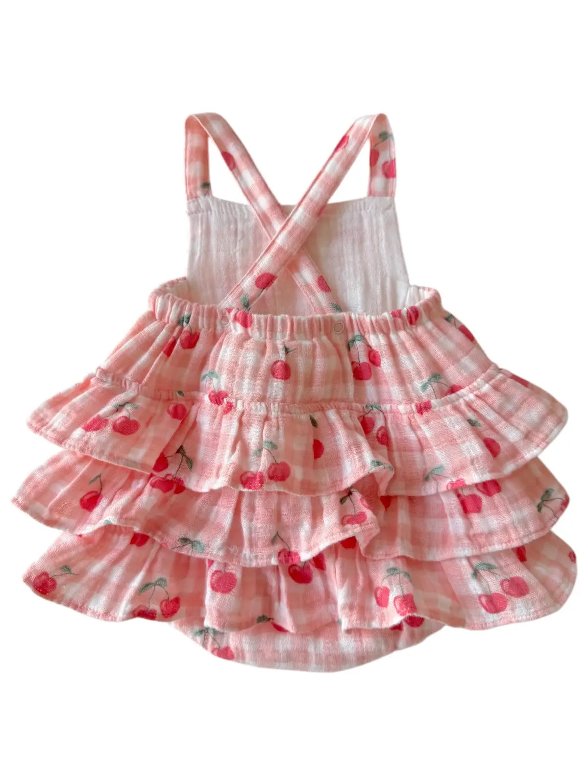 Pink tiered dress with cherry pattern on a white background