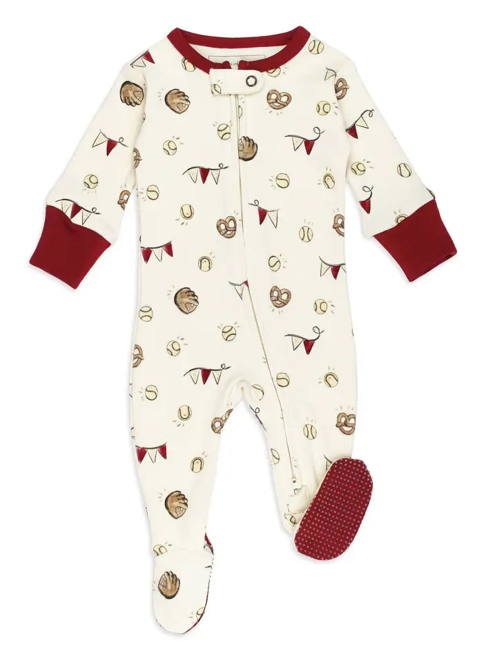 A baby footed sleeper in cream with a baseball pattern and dark red cuffs, collar, and sole.
