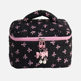 Black makeup bag with pink bow pattern and pink zipper on a white background