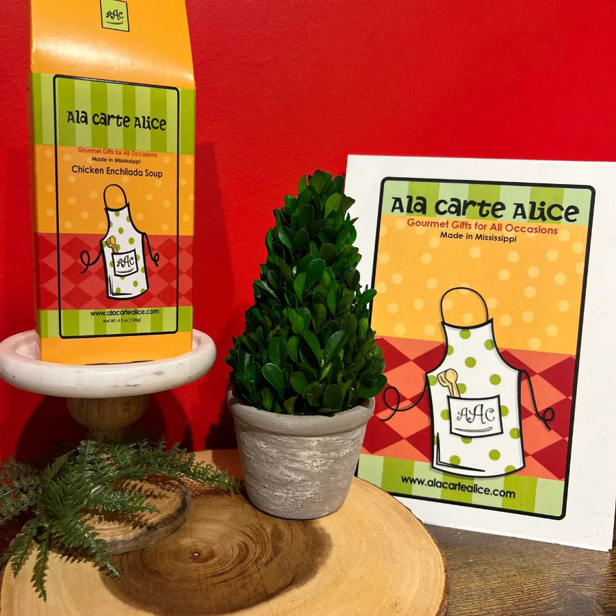 Ala carte Alice product packaging with a plant and card on a red background