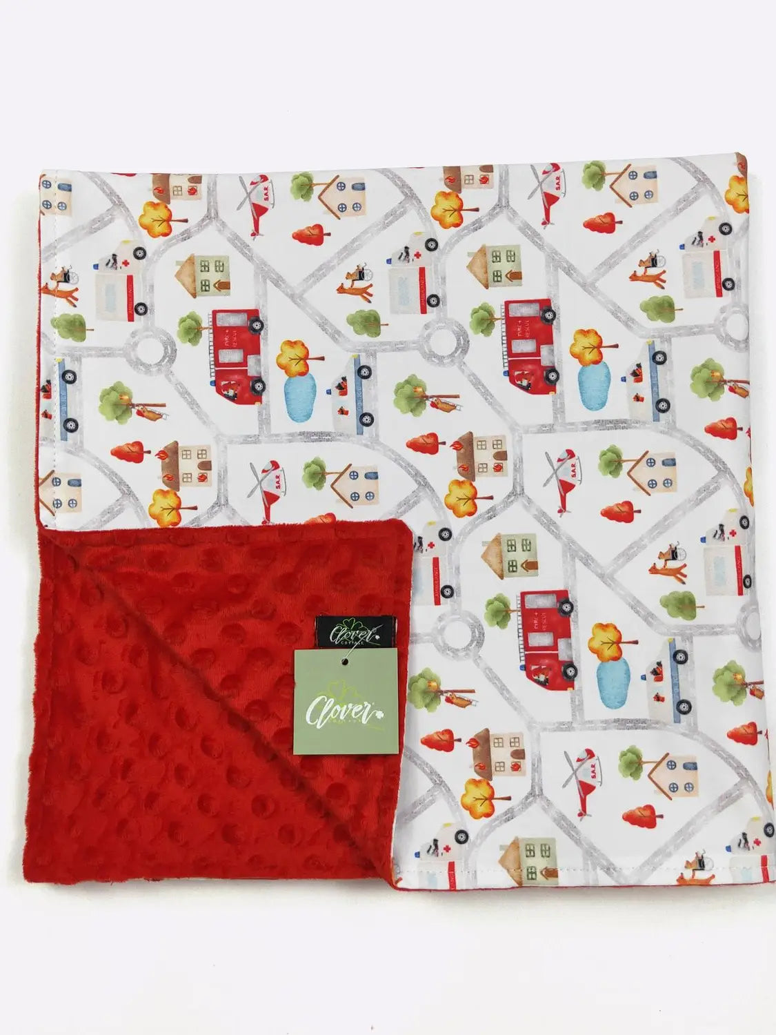 Baby blanket with road and vehicle pattern and red backside, featuring a label.