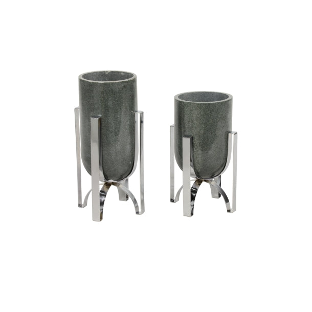 A pair of cylindrical marble vases with metal accents, one larger than the other, placed against a white background.