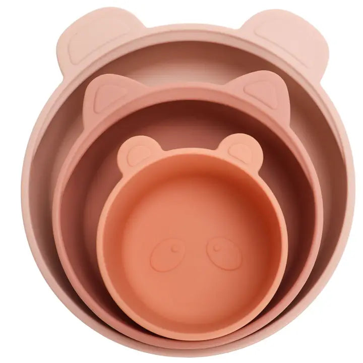 Set of three pink silicone bowls with bear ears and face on a white background