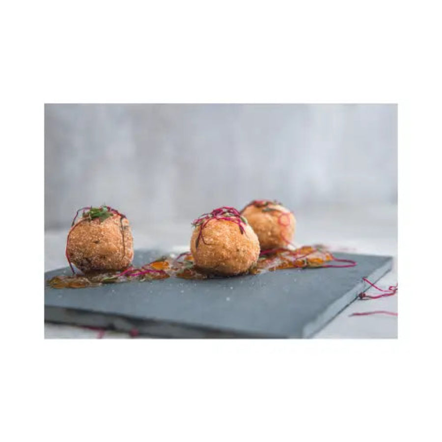 Three fried croquettes on a gray plate with a white background