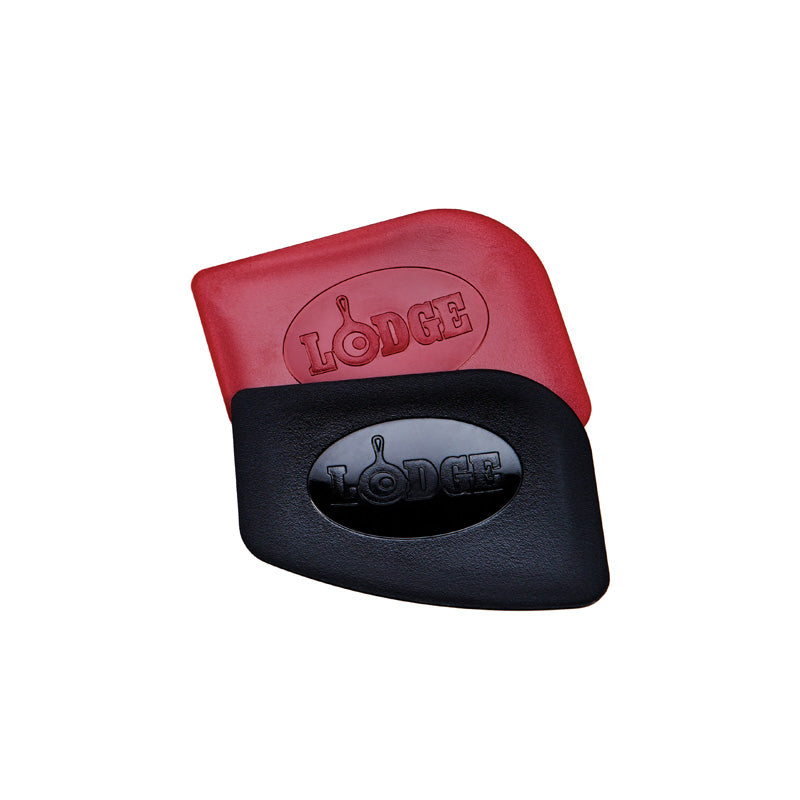 Two pan scrapers, one red and one black, each embossed with the Lodge brand name.