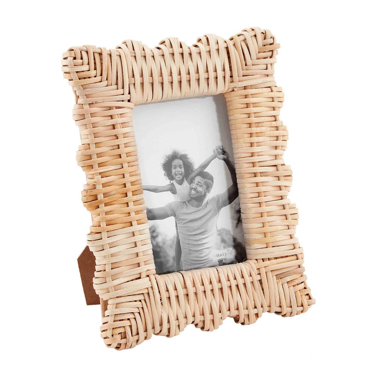 A 4x6 woven picture frame with a photograph of a family in an upright position.