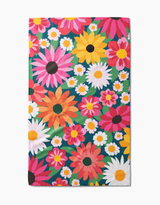 A colorful tea towel with a floral pattern featuring various colors such as pink, yellow, and green.
