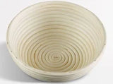 Round woven bread basket with concentric circles on a white background