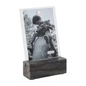 Black and white photo of a person on a stand with a wooden base