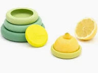 A set of silicone lemons and limes for making lemonade, including a green lid, a yellow lemon-shaped piece, and a yellow half-lemon, shown on a white background.